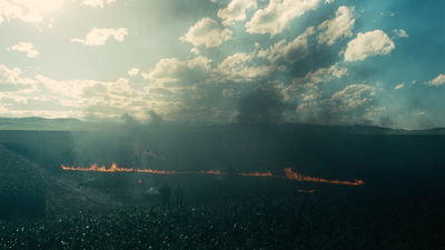 a large group of people standing around a fire