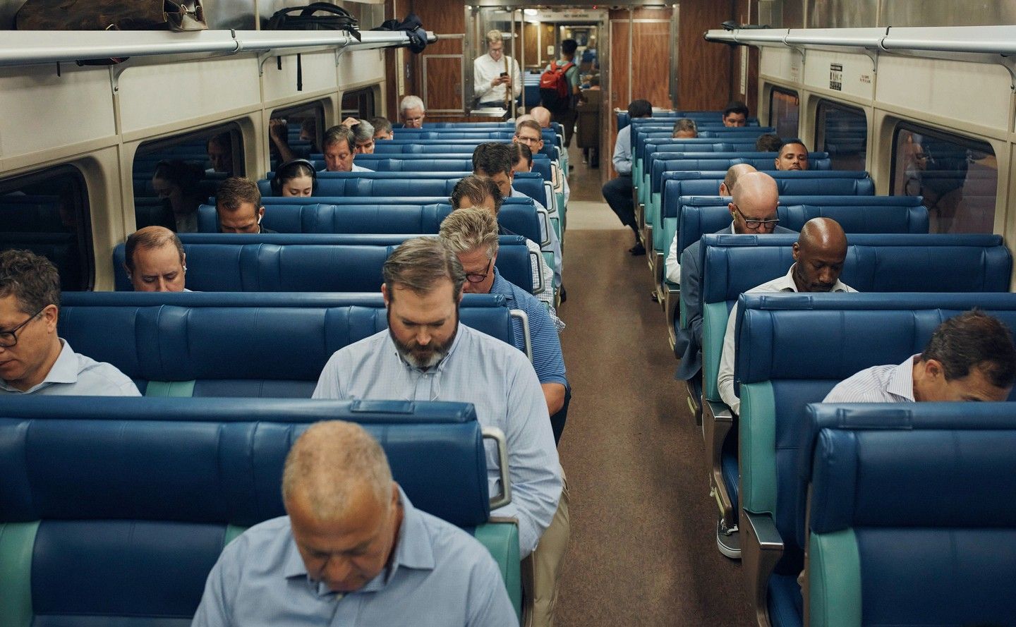 a group of people sitting on a train next to each other