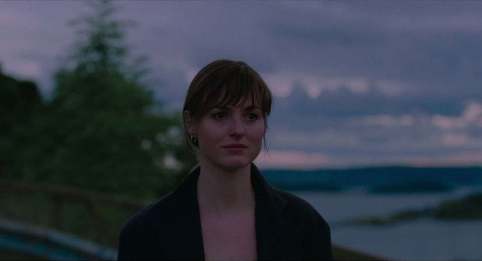 a woman standing in front of a body of water