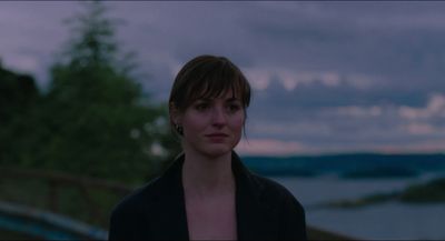 a woman standing in front of a body of water