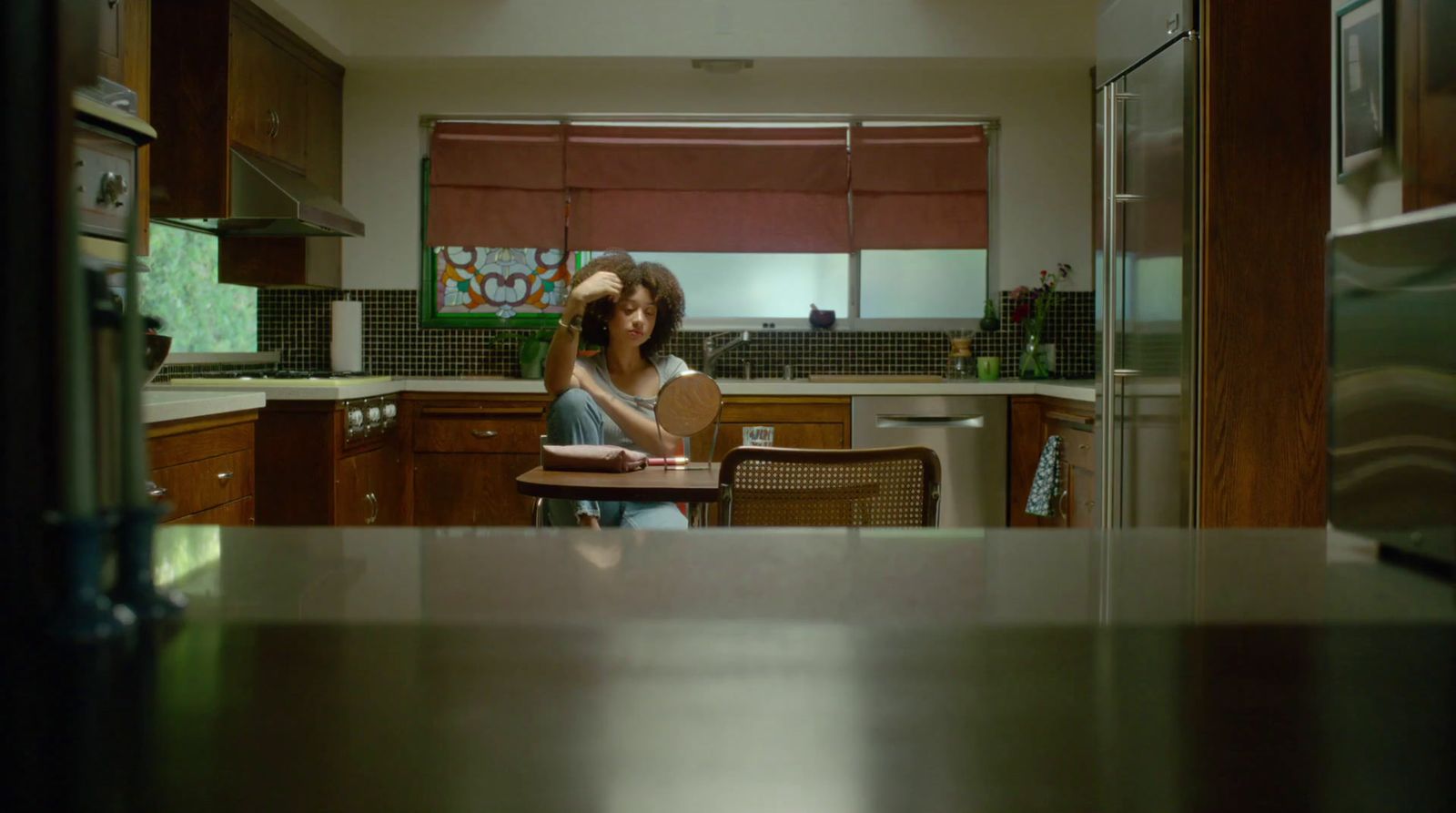 a woman standing in a kitchen next to a table