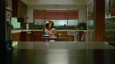 a woman standing in a kitchen next to a table
