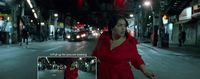 a woman in a red dress walking down a street