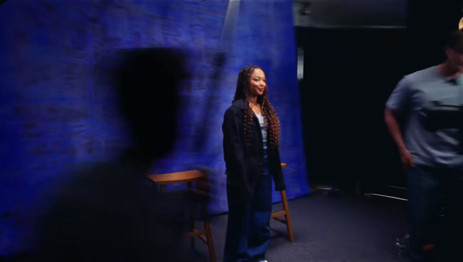 a woman standing in front of a blue backdrop