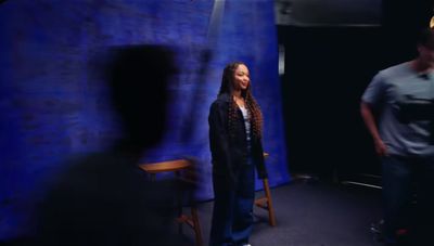 a woman standing in front of a blue backdrop