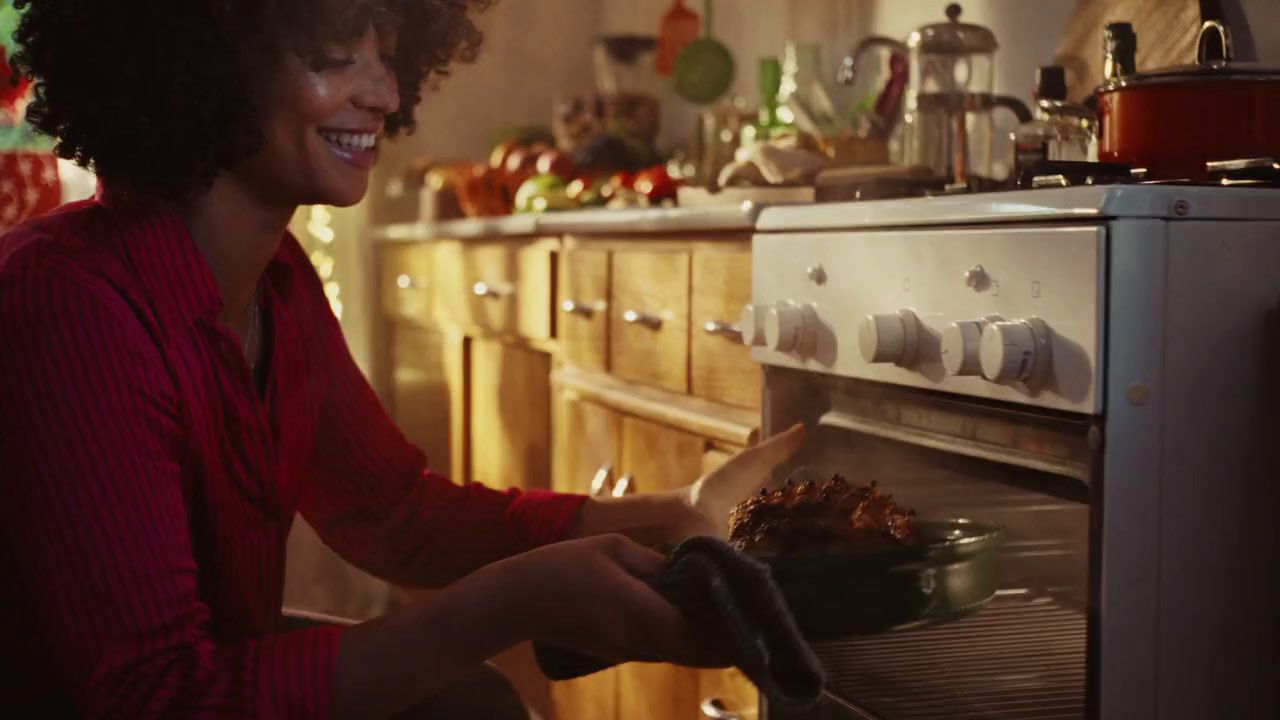 a woman putting food into an oven in a kitchen