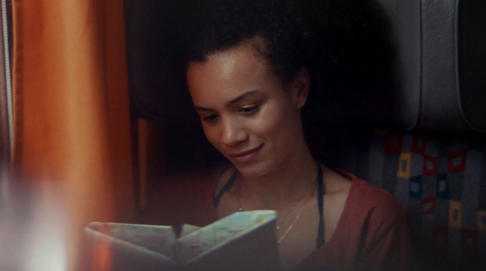 a woman reading a book in a train