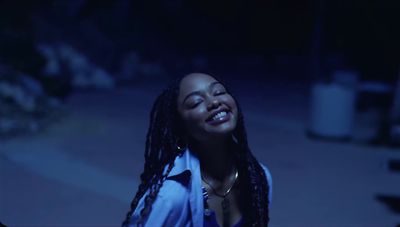 a woman with dreadlocks standing in the dark