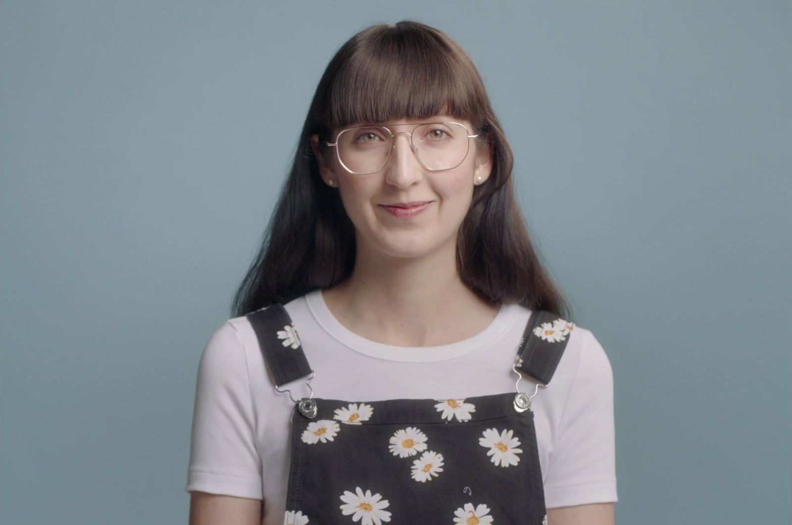 a woman wearing glasses and a black and white dress