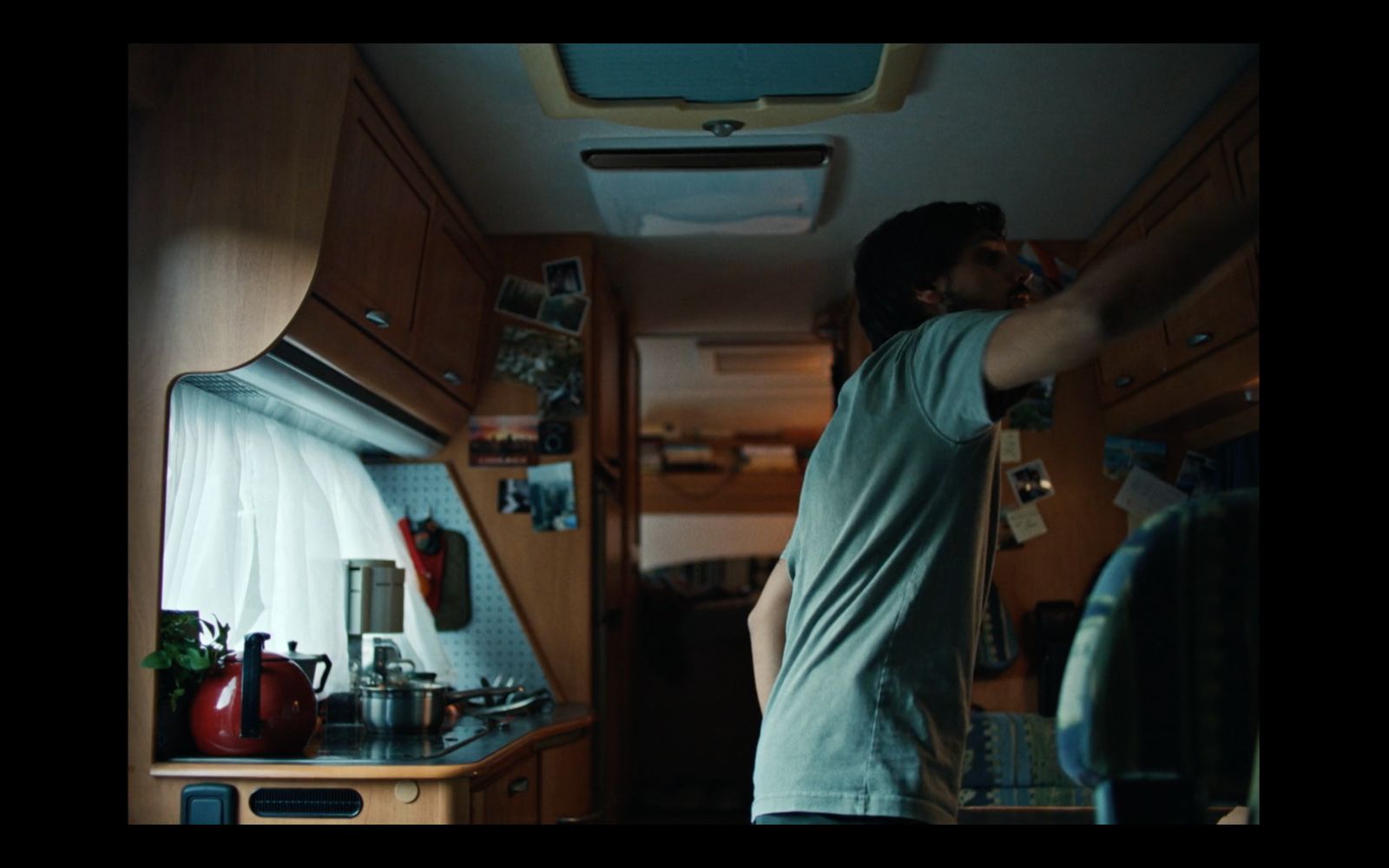 a man standing in a kitchen next to a stove top oven