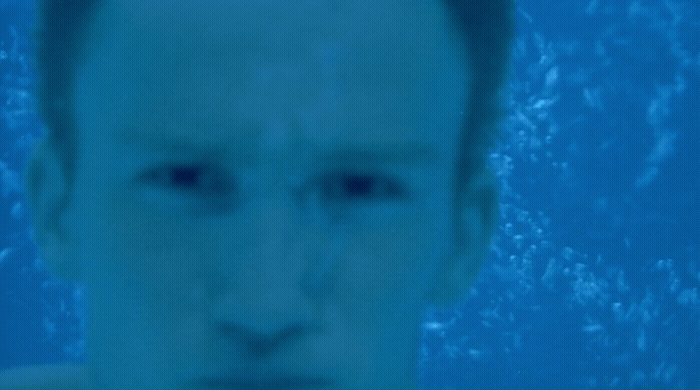 a man in a swimming pool looking at the camera