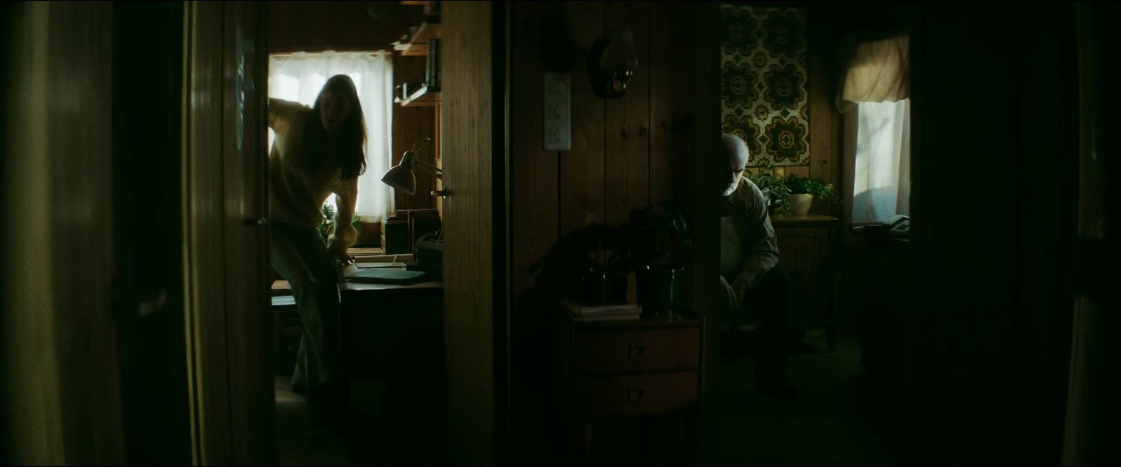 a woman standing in a dark room with her hair blowing in the wind