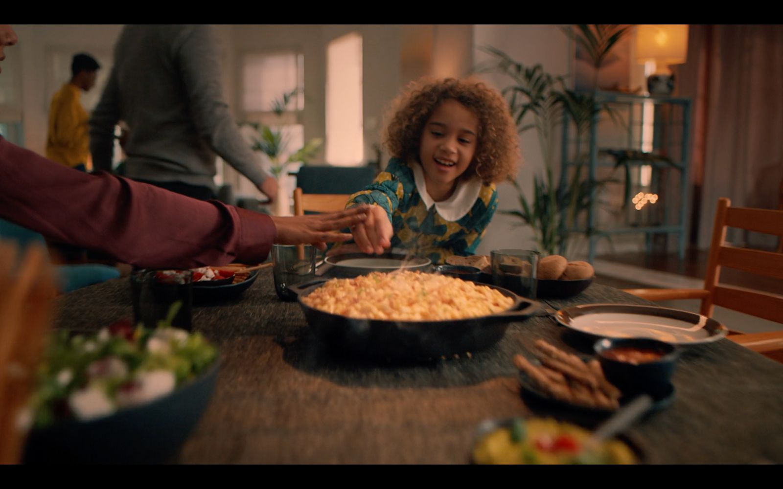 a woman sitting at a table in front of a bowl of food