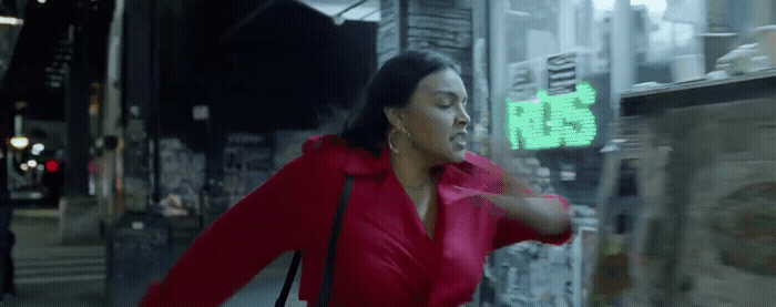 a woman in a red coat is walking down the street