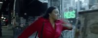 a woman in a red coat is walking down the street