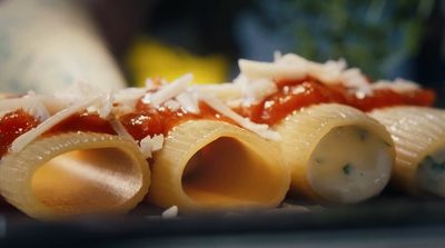 a close up of a plate of food with pasta and sauce