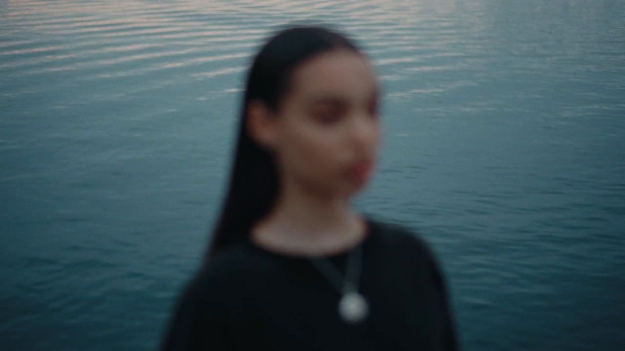 a woman standing in front of a body of water