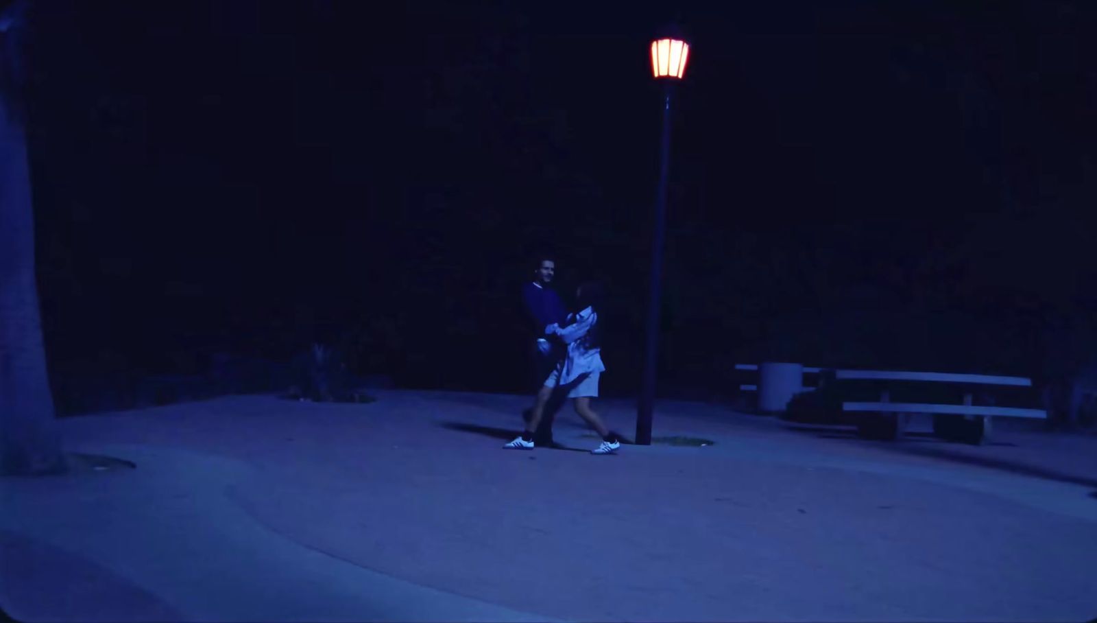 a woman walking down a street at night