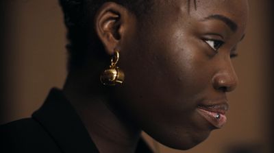 a close up of a person wearing a pair of earrings