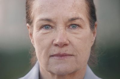 a close up of a person wearing a suit and tie