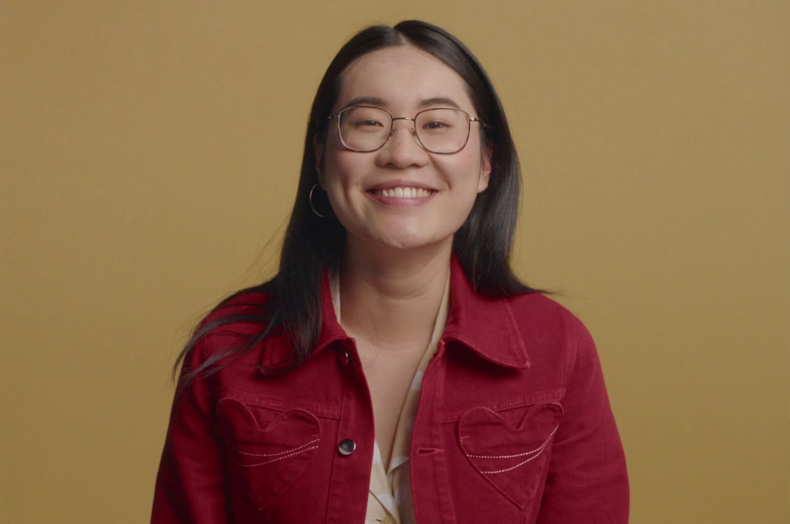 a woman wearing glasses and a red jacket