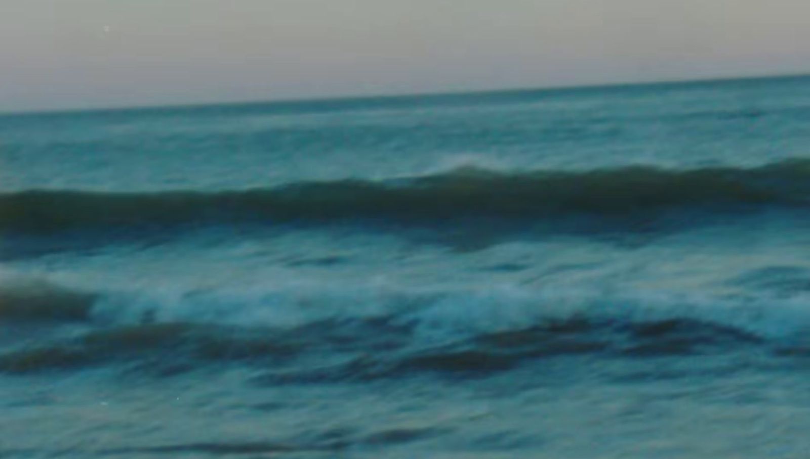 a man riding a wave on top of a surfboard