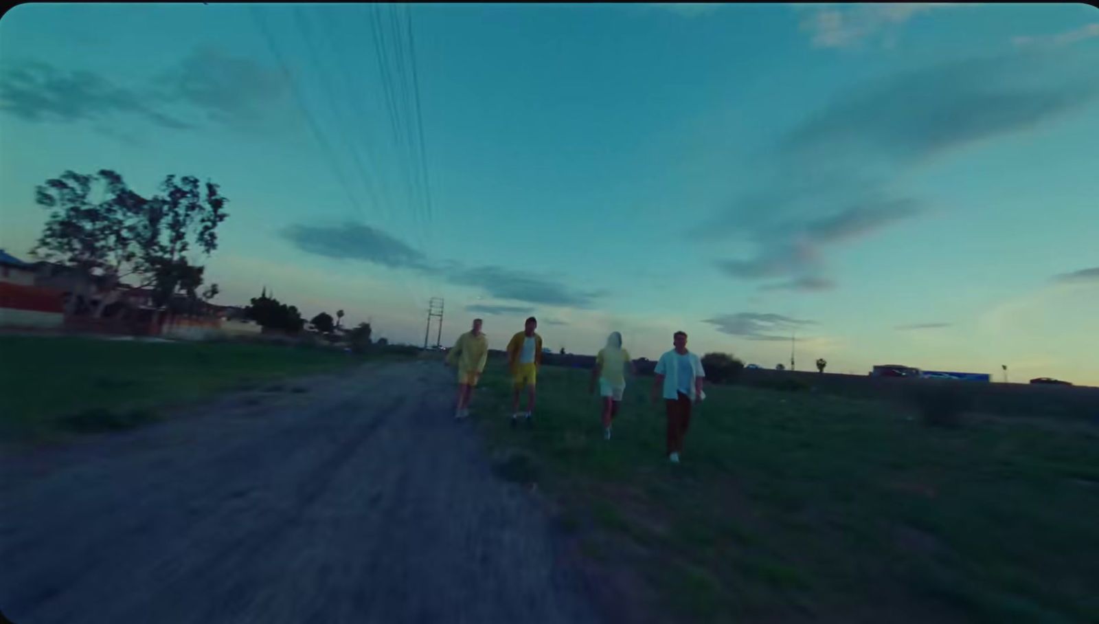 a group of people walking down a dirt road