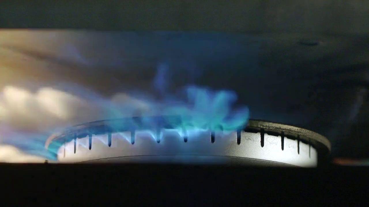 a blue flame is seen on a stove top