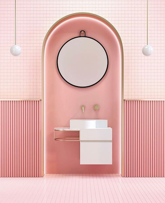 a bathroom with pink walls and a round mirror