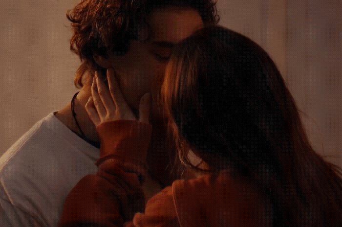 a man and a woman kissing in front of a mirror