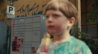 a young boy holding a popsicle in his hand