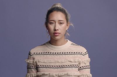 a woman in a sweater is making a funny face