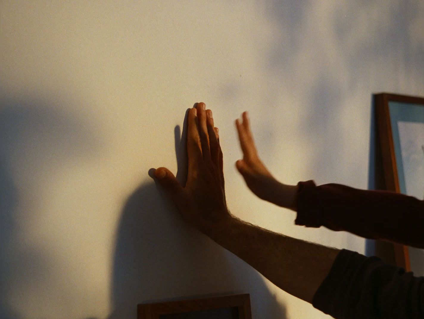 a person reaching up to a wall with their hands