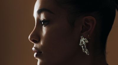 a close up of a person wearing a pair of earrings