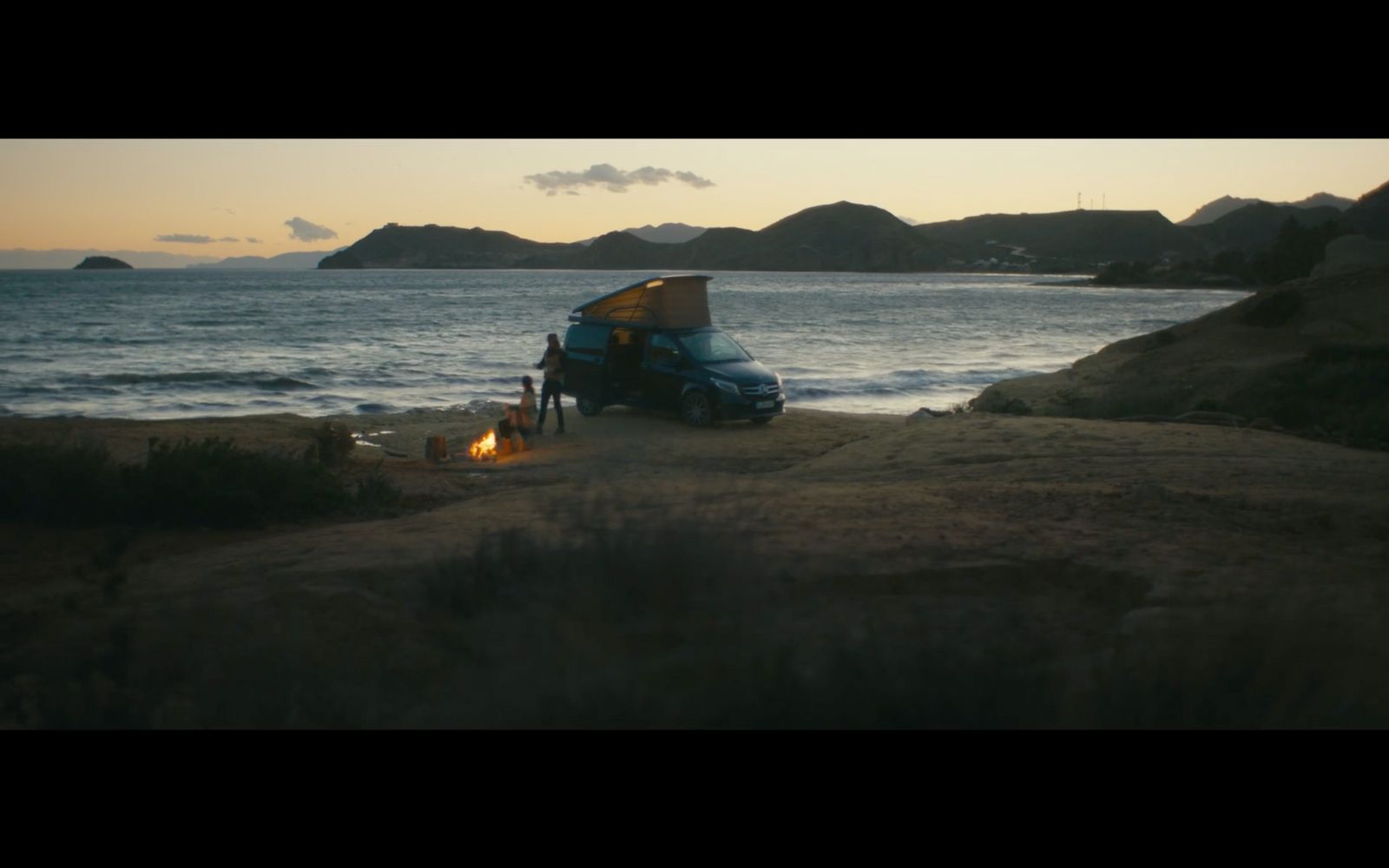 a car parked on the side of a beach next to the ocean