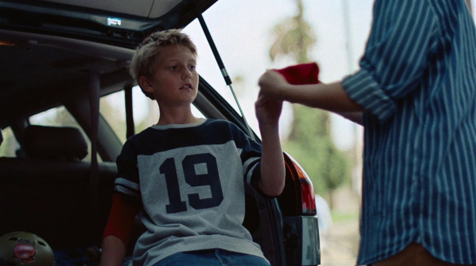 a young boy sitting in the back of a car