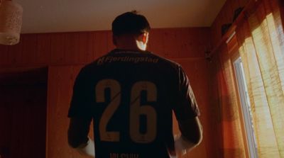 a man standing in a room wearing a jersey