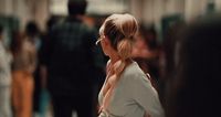 a woman standing in a hallway with her back to the camera