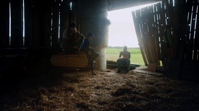 a group of people sitting on top of a pile of hay