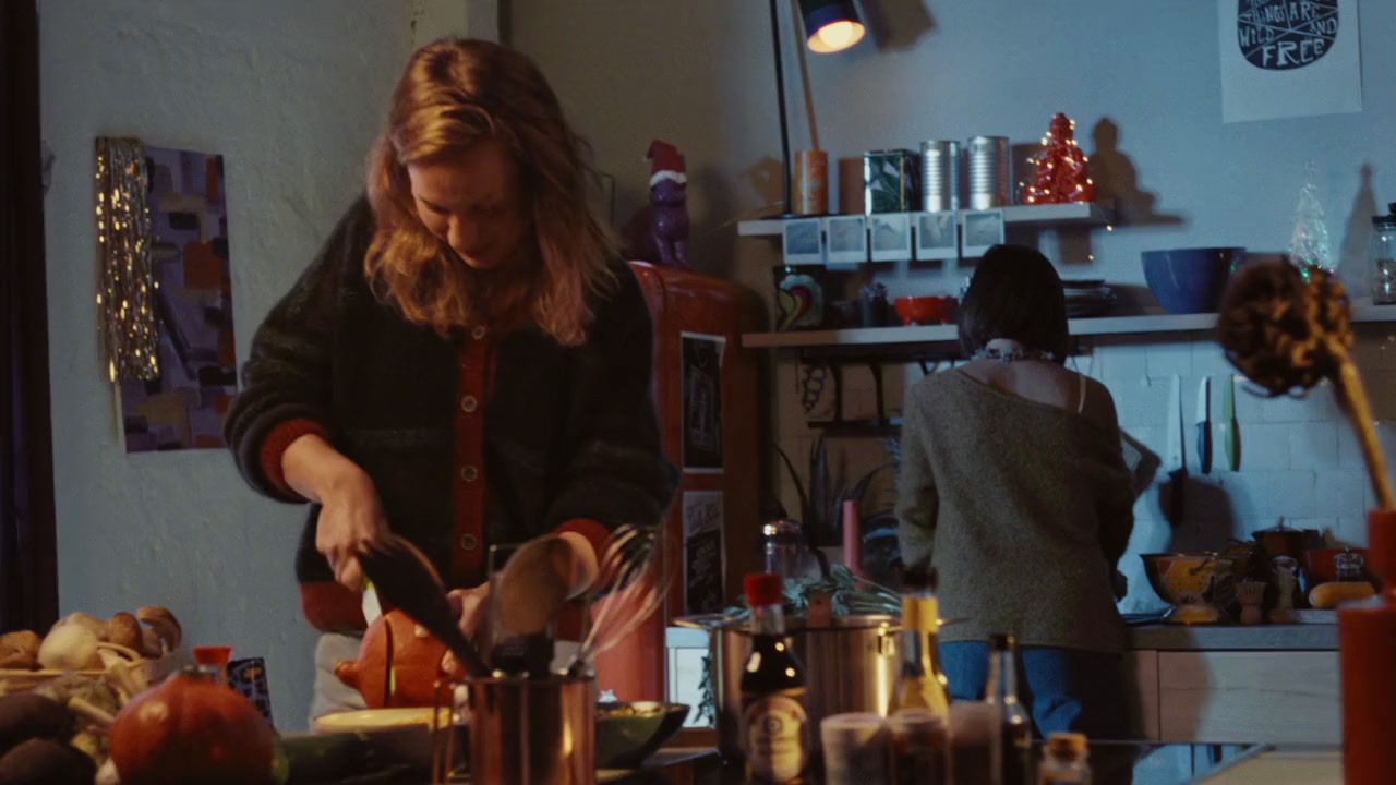 a woman standing in a kitchen preparing food