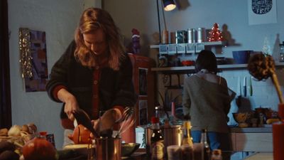 a woman standing in a kitchen preparing food