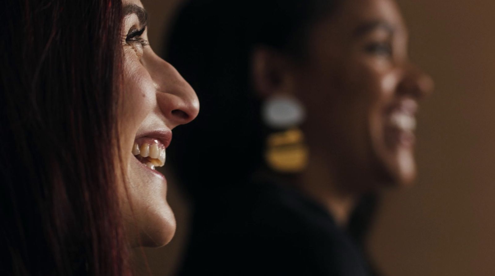 two women are smiling and laughing together