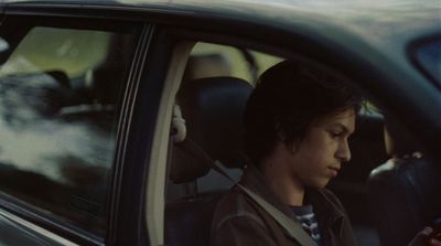 a man sitting in a car using a cell phone
