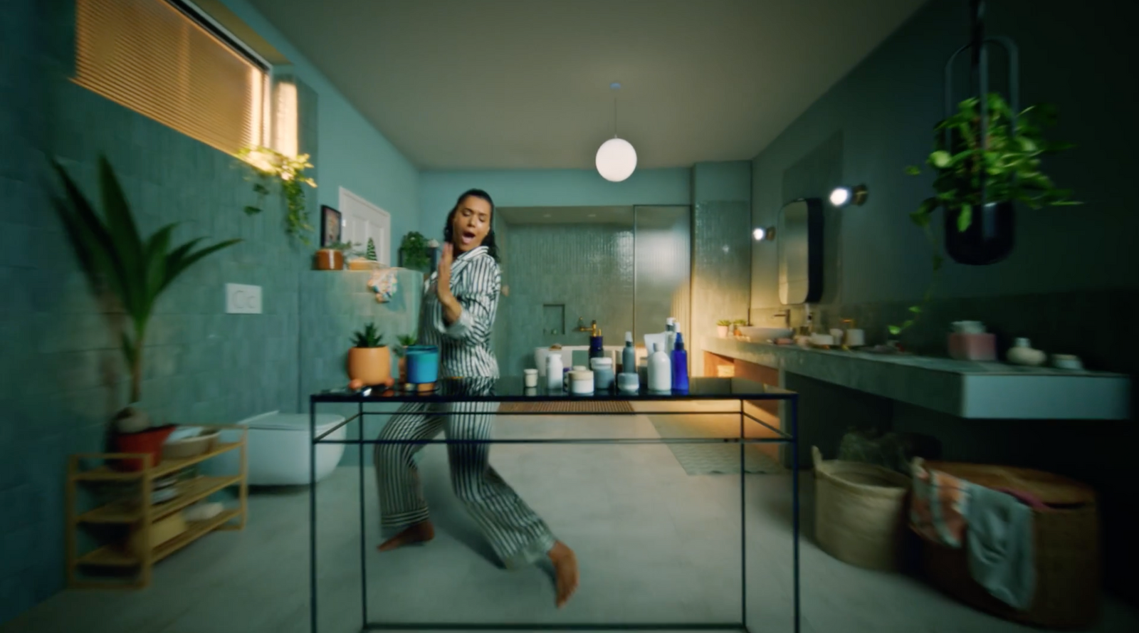 a woman standing in a bathroom next to a sink