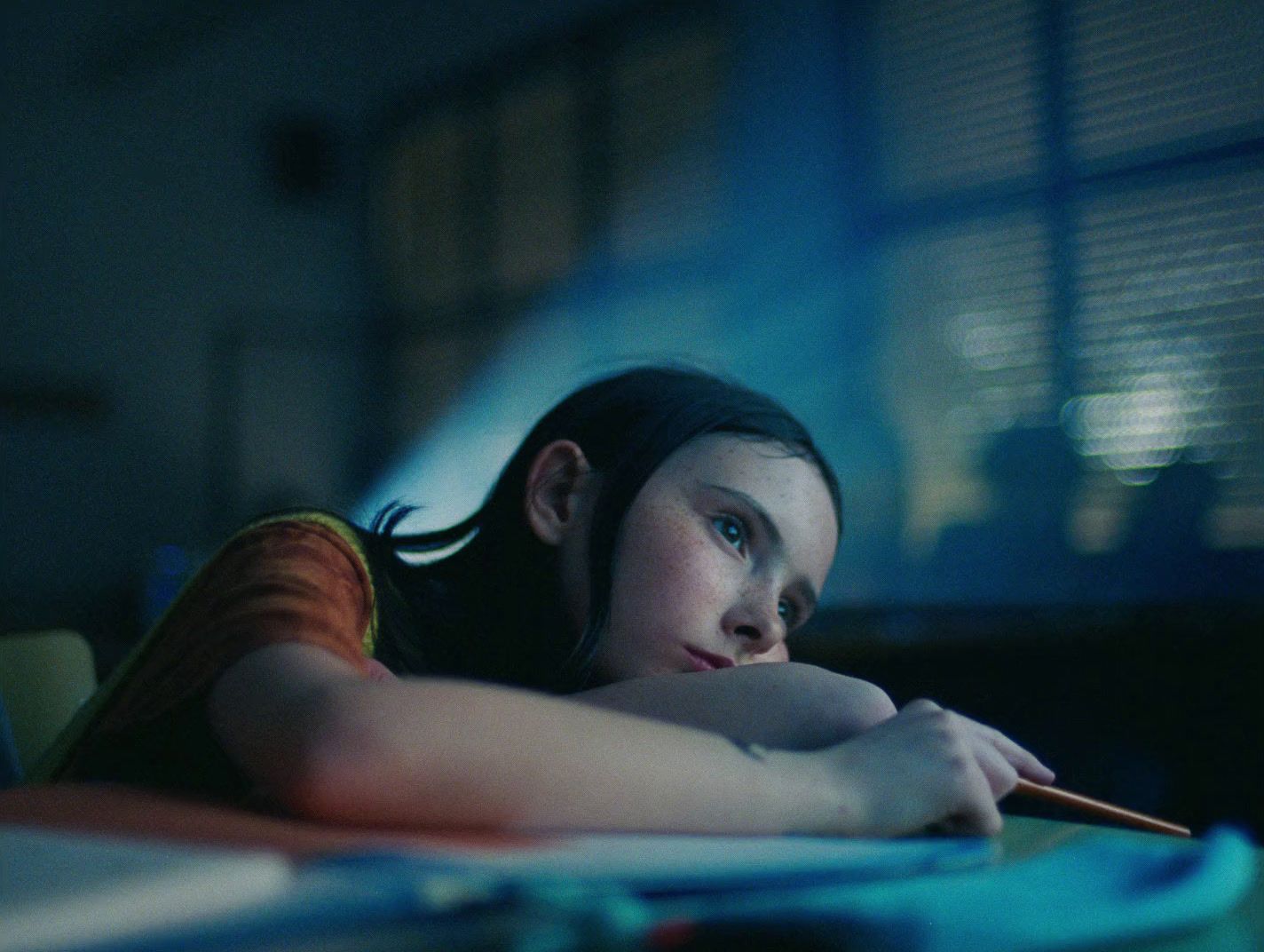 a woman laying on a table with a pencil in her hand