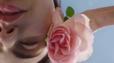 a close up of a person holding a flower