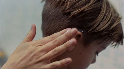 a close up of a person touching their ear