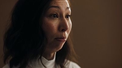 a woman with freckled hair and a white shirt