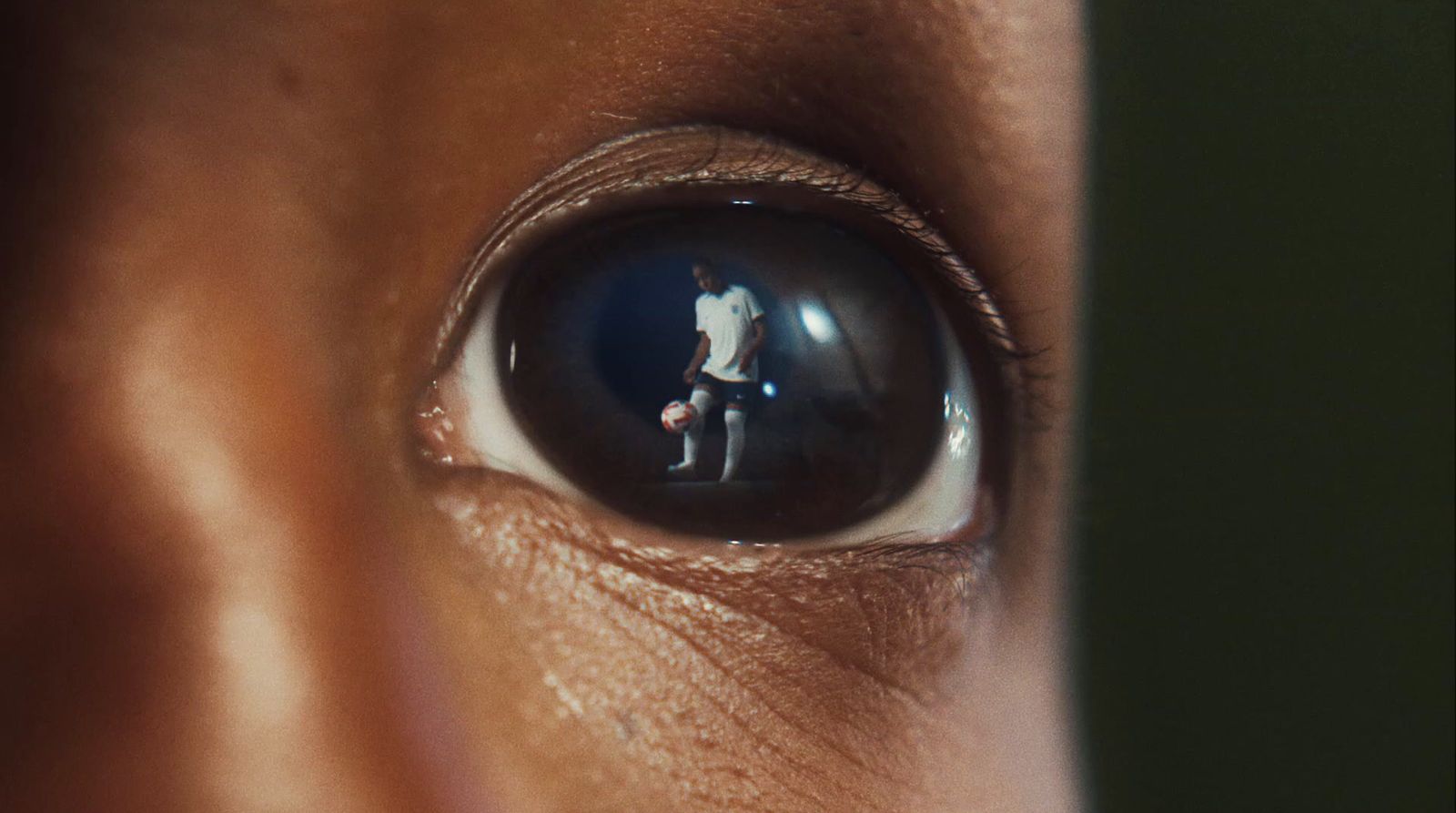 a close up of a person's eye with the reflection of a man in