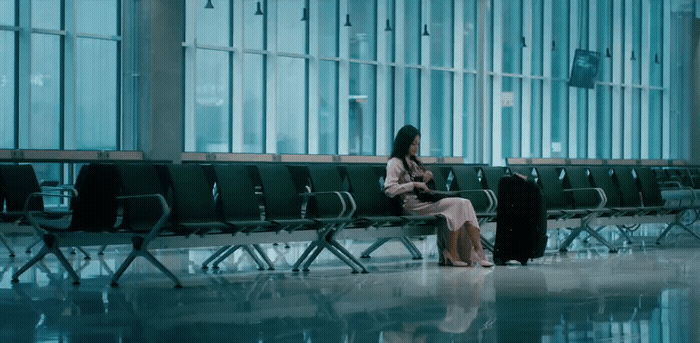 a woman sitting on a bench in an airport